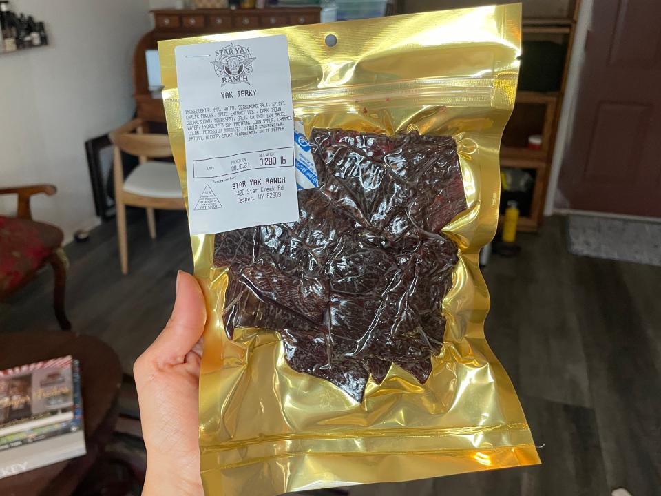 hand holding gold bag of yak star farms yak jerky