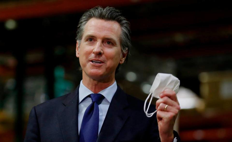 Gov. Gavin Newsom displays a face mask as he urges people to wear them to fight the spread of the coronavirus during a news conference in Rancho Cordova on Friday, June 26, 2020. Newsom said he wants Imperial County in Southern California to reimpose a stay-at-home order amid a surge in positive coronavirus tests.