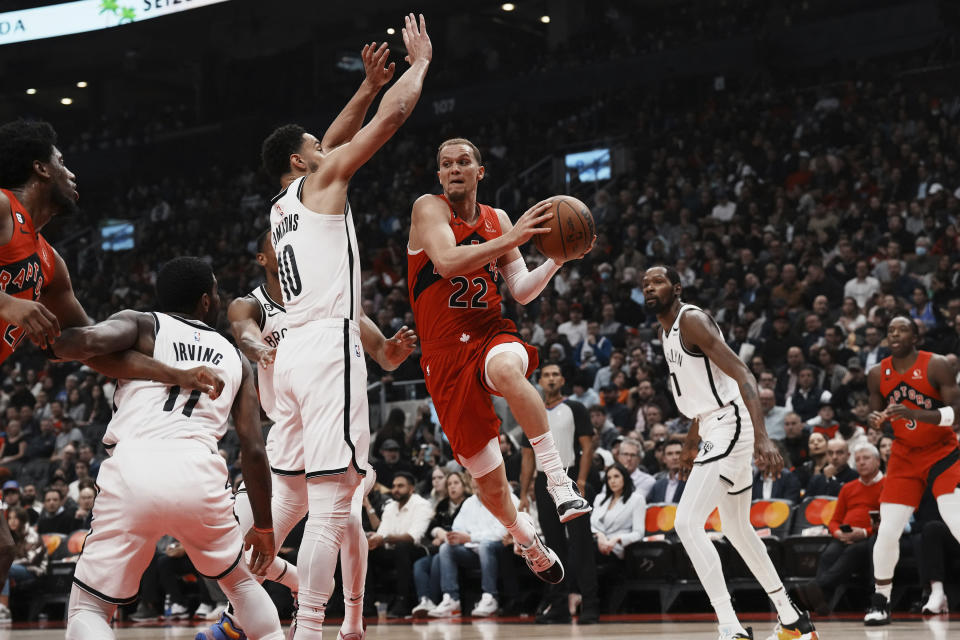 Toronto Raptors guard Malachi Flynn looks to pass around Brooklyn Nets' Ben Simmons during the first half of an NBA basketball game Wednesday, Nov. 23, 2022, in Toronto. (Chris Young/The Canadian Press via AP)