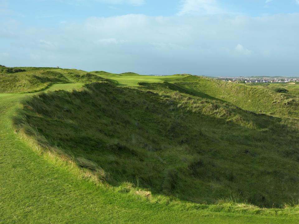 The 236-yard 16th, Calamity Corner, is guarded by what Bernhard Darwin described as a terrifying descent "into unknown depths."