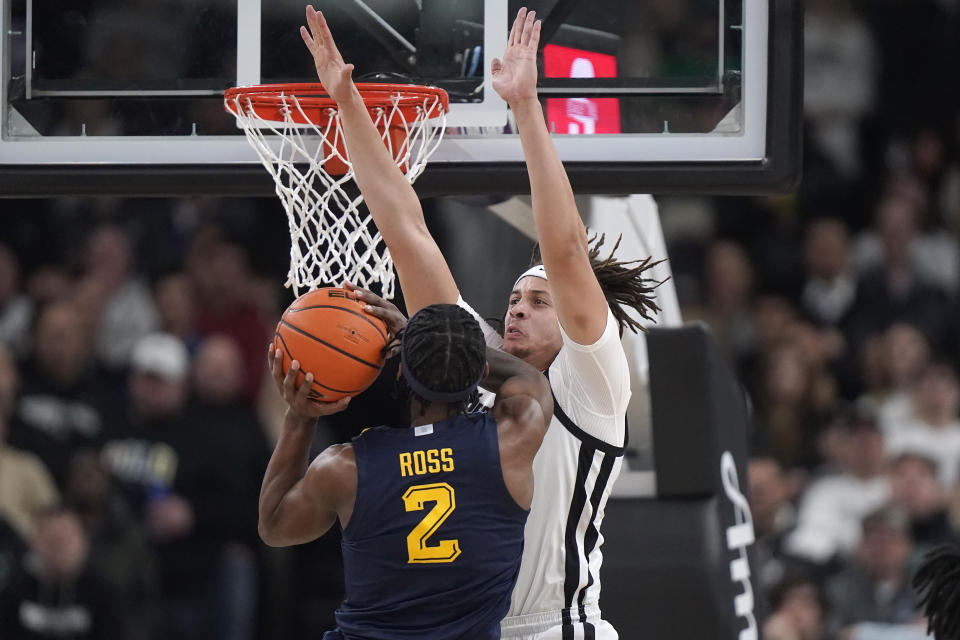 Marquette guard Chase Ross (2) drives toward the basket as Providence forward Josh Oduro defends during the first half of an NCAA college basketball game Tuesday, Dec. 19, 2023, in Providence, R.I. (AP Photo/Steven Senne)