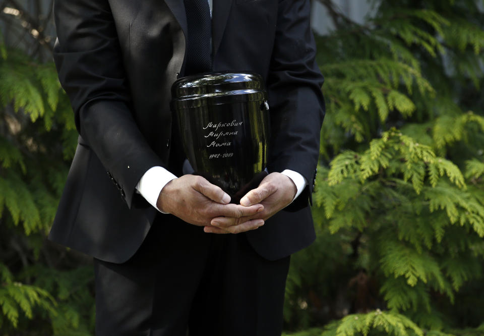 A family friend Slobodan Bulatovic holds urn with ashes of Mirjana Markovic, the widow of former strongman Slobodan Milosevic during her funeral at the yard of his estate in his home town of Pozarevac, Serbia, Saturday, April 20, 2019. Markovic died last week in Russia where she had been granted asylum. The ex-Serbian first lady had fled there in 2003 after Milosevic was ousted from power in a popular revolt and handed over to the tribunal in The Hague, Netherlands. (AP Photo/Darko Vojinovic)