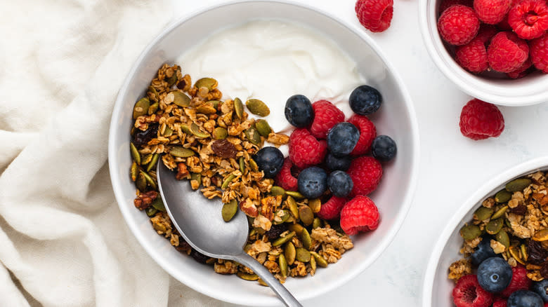 Pumpkin seed granola in bowl with berries and yogurt