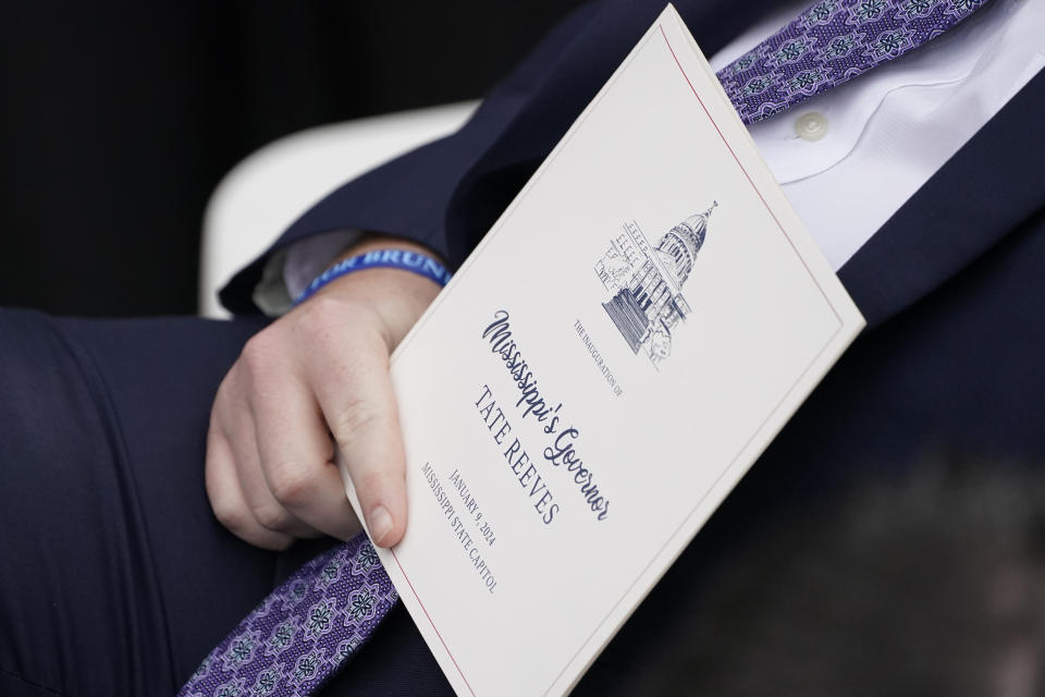 A guest at the inauguration of Mississippi Gov. Tate Reeves holds a program at the Mississippi State Capitol in Jackson, Miss., Tuesday, Jan. 9, 2024. (AP Photo/Rogelio V. Solis)