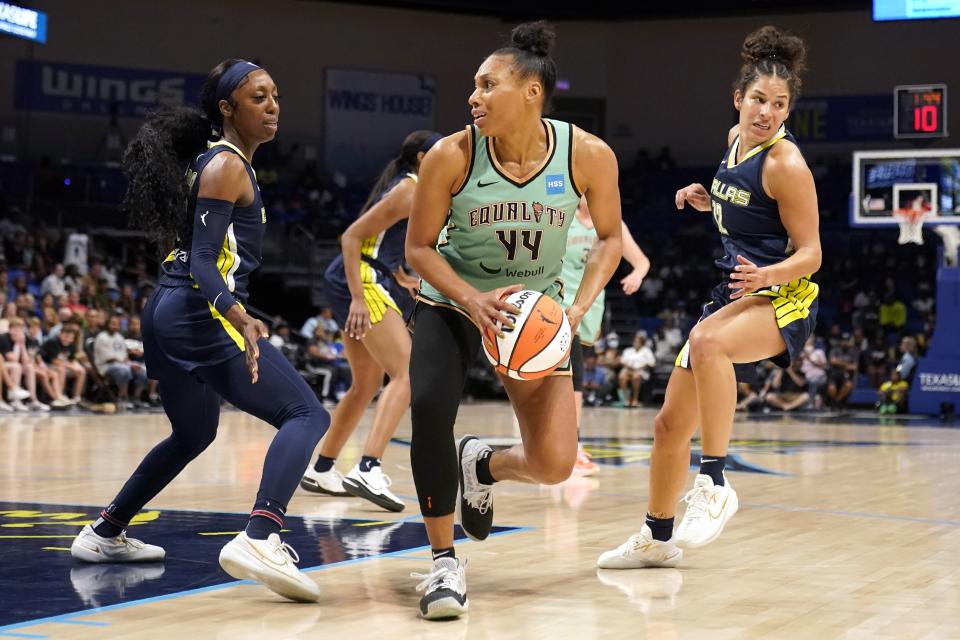 New York Liberty forward Betnijah Laney (44) is defended by Dallas Wings' Jasmine Dickey, left, and Veronica Burton during the second half of a WNBA basketball game in Arlington, Texas, Wednesday, Aug. 10, 2022. (AP Photo/Tony Gutierrez)