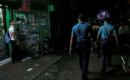 Policemen from Caloocan Police District patrol a dimly lit alley at a residential district in Caloocan City Metro Manila Philippines, September 14, 2017. Picture taken September 14, 2017. REUTERS/Erik De Castro