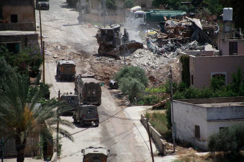 Israeli army vehicles block a road during a raid in the West Bank town of Deir al-Ghusun near Tulkarem. Mohammed Nasser/APA Images via ZUMA Press Wire/dpa