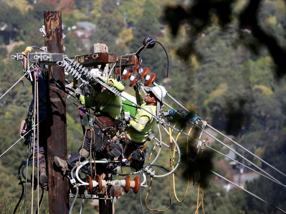 Workers replace a power line pole in California