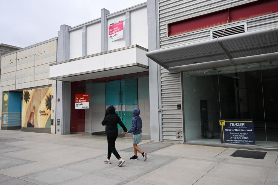 People walk past vacant storefronts on the Third Street Promenade in Santa Monica