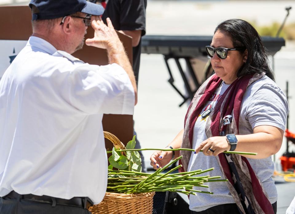 Alicia Lopez, mother of Marine Cpl. Hunter Lopez, places a white rose in a basket to be flown in the annual flower drop along with other gold star families in the annual Memorial Day ceremony at the Palm Springs Air Museum in Palm Springs, Calif., Monday, May 30, 2022.