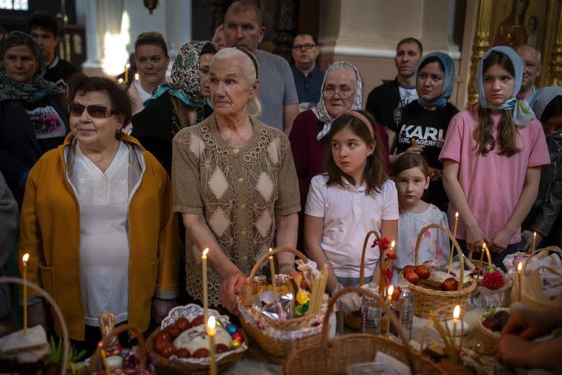 Believers wait for a Lithuanian Orthodox priest to bless their collected traditional cakes and painted eggs for their Easter celebration on 5 May.