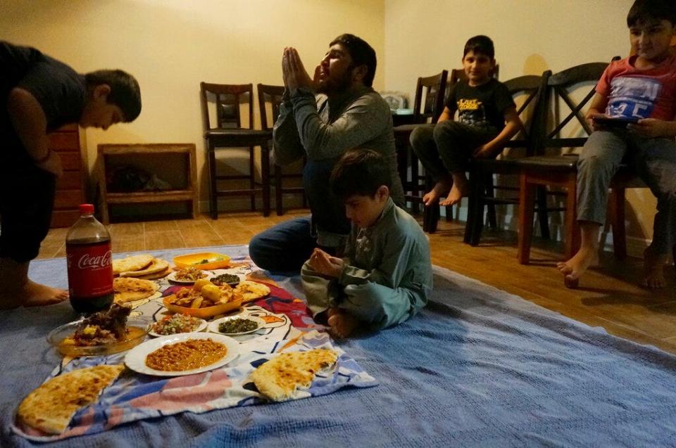 Shel Alam Momand prays before breaking the Ramadan fast at his new apartment in El Paso on Sunday, April 3, 2022. Momand, his wife and six children are among thousands of Afghans evacuated to the United States as the Taliban regained power last summer who are celebrating their first Muslim holy month of Ramadan in the U.S.