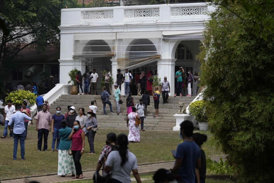 Protesters walk around and spend time a day after storming into prime minister's official residence in Colombo, Sri Lanka, Sunday, July 10, 2022. Sri Lanka’s opposition political parties will meet Sunday to agree on a new government a day after the country’s president and prime minister offered to resign in the country’s most chaotic day in months of political turmoil, with protesters storming both officials’ homes and setting fire to one of the buildings in a rage over the nation’s economic crisis.. (AP Photo/Eranga Jayawardena)