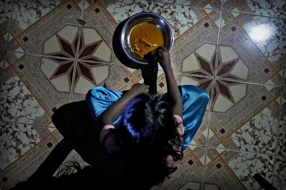 Madushika, 8, daughter of Rasarathnam Anushiya eats her dinner at their rented house in Vavuniya, about 250 kilometres north east of Colombo, Sri Lanka, Tuesday, Dec. 13, 2022. Due to Sri Lanka's current economic crisis families across the nation have been forced to cut back on food and other vital items because of shortages of money and high inflation. Many families say that they can barely manage one or two meals a day. (AP Photo/Eranga Jayawardena)