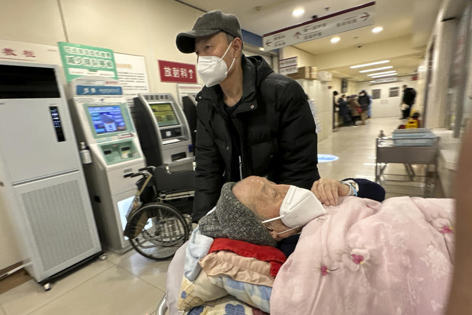 An elderly patient is pushed along a corridor of the emergency ward at a hospital in Beijing, Saturday, Dec. 31, 2022. China is on a bumpy road back to normal life as schools, shopping malls and restaurants fill up again with the easing of COVID-19 restriction. The abrupt end to testing and other measures came as hospitals were swamped with feverish, wheezing COVID-19 patients (AP Photo/Ng Han Guan)
