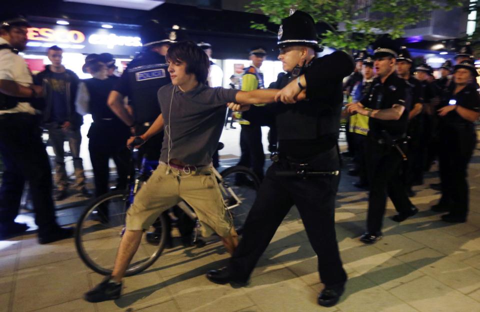 An officer arrests a cyclist after a Critical Mass bike protest outside the Olympic Park during the 2012 Summer Olympics Opening Ceremony, Friday, July 27, 2012, in London. (AP Photo/Matt Rourke)