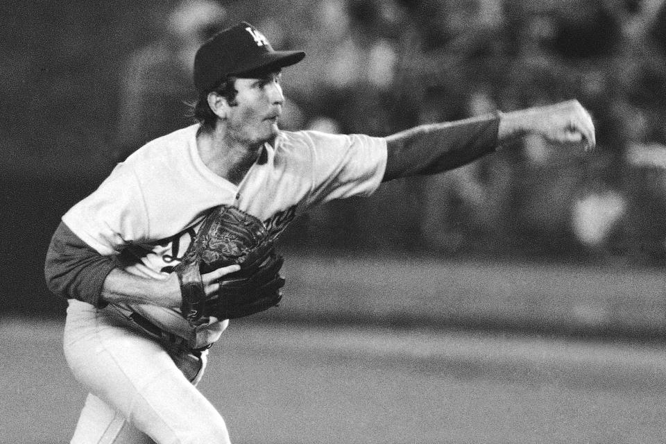 FILE - Tommy John of the Los Angeles Dodgers follows through on a pitch on his way to a 3-2 victory over the New York Mets at Shea Stadium in New York on Friday, June 15, 1974. There is a bridge that runs from Tommy John and Dr. Frank Jobe in 1974, all the way to Shohei Ohtani, Justin Verlander and Bryce Harper. A thread that connects an increasing number of baseball's biggest stars. Mostly on the mound, but at the plate, too. An operation that changed everything. (AP Photo/Ray Stubblebine, File)