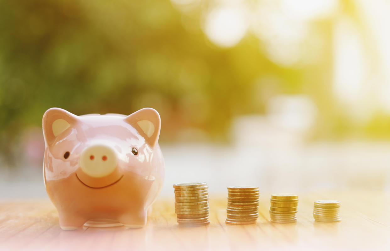 piggy bank with coins arranged in a graph on wooden table and green background, Finance or Savings concept.