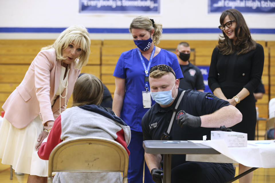 First lady Jill Biden and actress Jennifer Garner, right, speak to people being vaccinated for COVID-19 at Capitol High School in Charleston, W.Va., Thursday, May 13, 2021. (Oliver Contreras/The New York Times via AP, Pool)