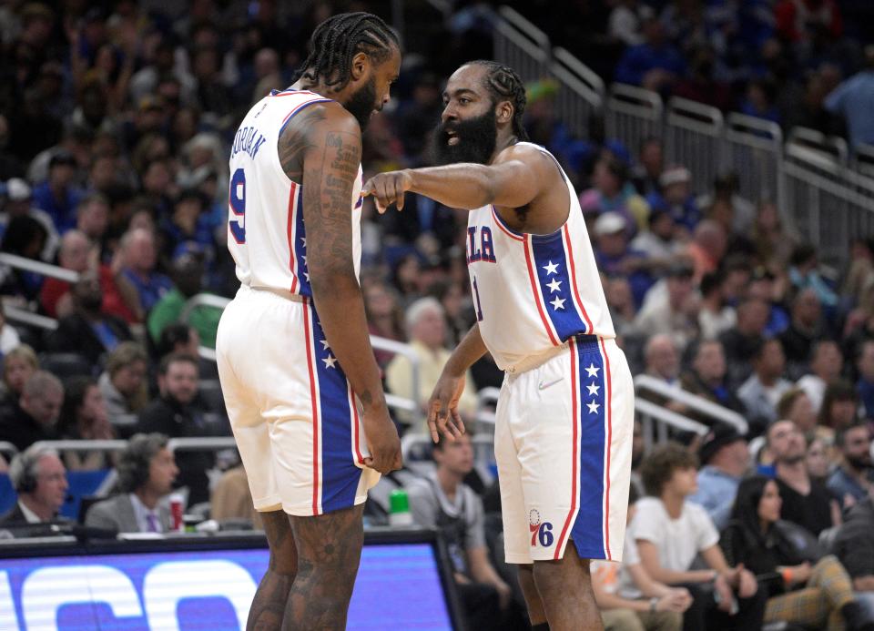 Philadelphia 76ers guard James Harden (1) talks to center DeAndre Jordan (9) on the court after a timeout during the second half of an NBA basketball game against the Orlando Magic, Sunday, March 13, 2022, in Orlando, Fla. (AP Photo/Phelan M. Ebenhack)