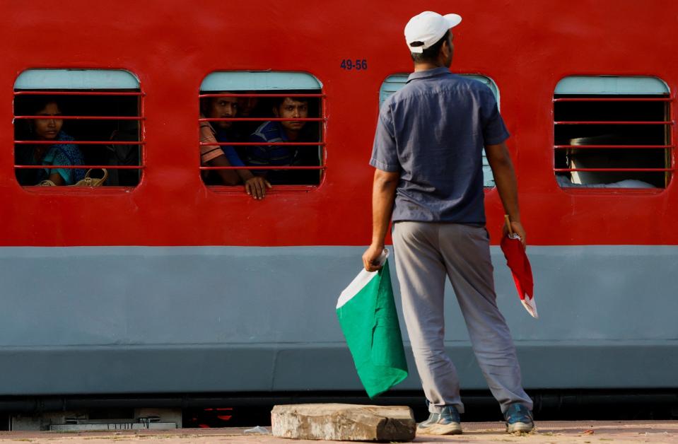 A train arrives at the Bahanaga Bazar railway station as a signal-man looks on from the platform (REUTERS)