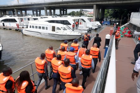 FILE PHOTO: Uber officials walk with life vests at the five cowries terminal during the company's boat service launch in Lagos
