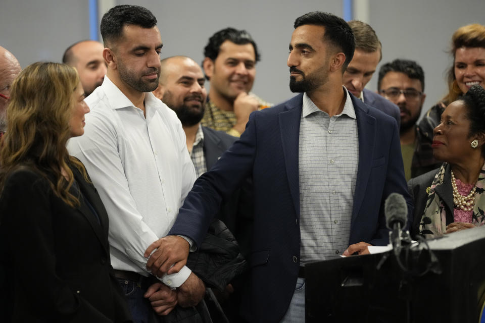 Abdul Wasi Safi, center, holds the hand of his brother, Sami-ullah Safi, left, as U.S. Rep. Sheila Jackson Lee, D-Texas, looks on during a news conference Friday, Jan. 27, 2023, in Houston. Wasi Safi, an intelligence officer for the Afghan National Security Forces who fled Afghanistan following the withdrawal of U.S. forces, was freed this week and reunited with his brother after spending months in immigration detention. (AP Photo/David J. Phillip)