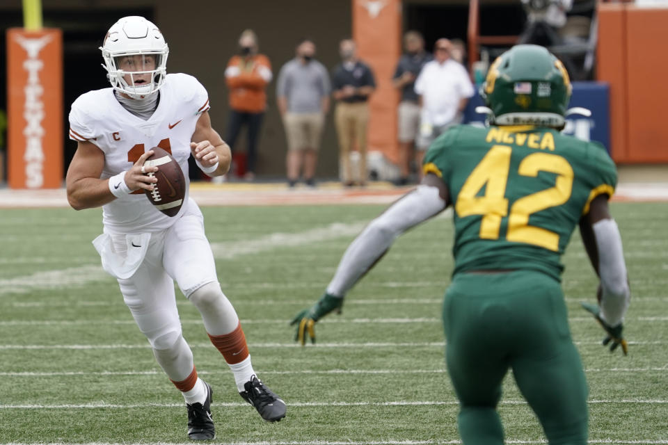 Texas' Sam Ehlinger (11) scrambles against Baylor's Jairon McVea (42) during the first half of an NCAA college football game in Austin, Texas, Saturday, Oct. 24, 2020. (AP Photo/Chuck Burton)