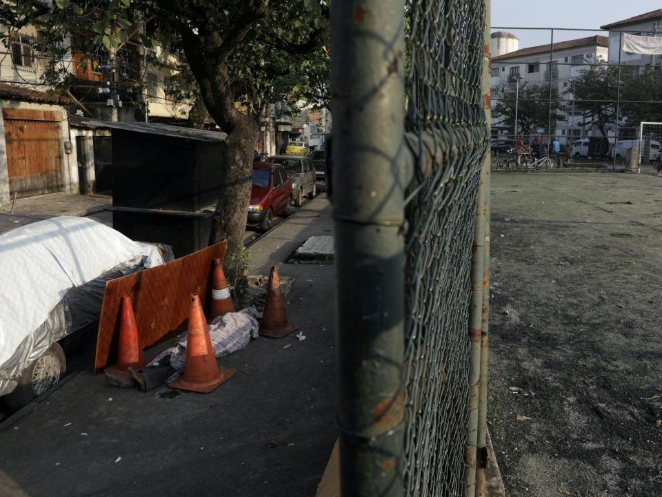 The body of Valnir Mendes da Silva lies on a sidewalk where he died in Rio de Janeiro, Brazil, May 2020, during the coronavirus crisis.