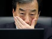 FILE PHOTO: Kurokawa, head of parliamentary committee investigating causes of Fukushima accident, looks at laptop monitor during a news conference in Tokyo