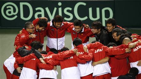 Japan's captain Minoru Ueda (top L), Kei Nishikori (top 2nd L) celebrate with their team members after defeating Canada during their Davis Cup world group first round tennis match in Tokyo February 2, 2014. REUTERS/Toru Hanai