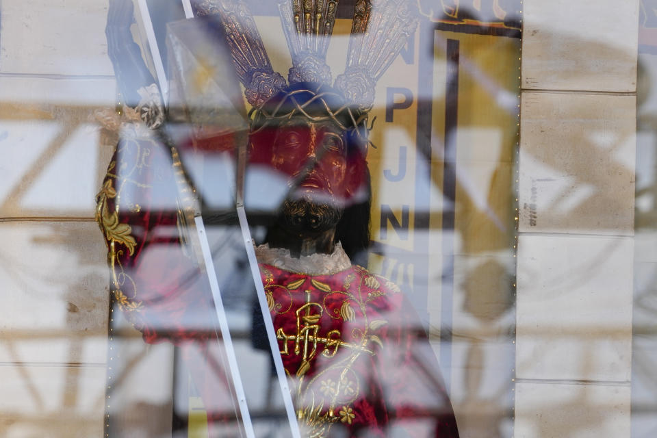 An image of the Black Nazarene is seen through glass as part of celebrations for his feast day and the "Walk of Faith" procession at the Quirino Grandstand on Saturday Jan. 7, 2023. The annual Black Nazarene procession which is attended by hundreds of thousands of devotees has been cancelled due to COVID concerns. (AP Photo/Aaron Favila)