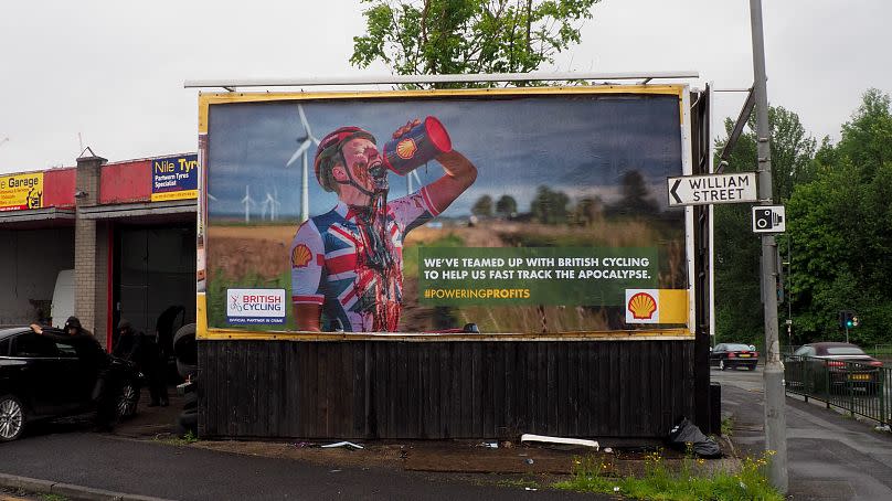 A satirical billboard in Manchester shows a cyclist drinking oil. 