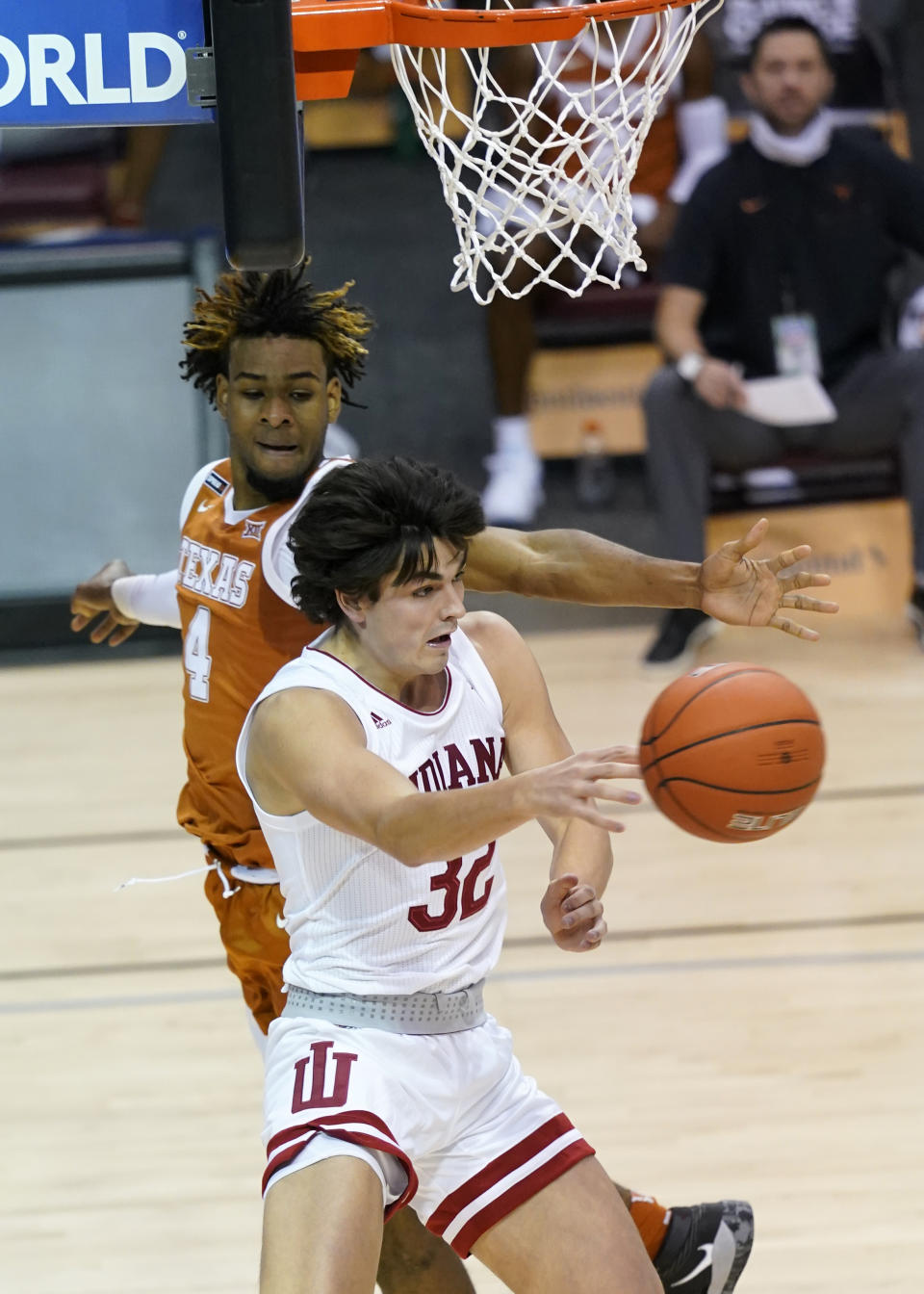 Indiana guard Trey Galloway (32) pass the ball away from Texas forward Greg Brown (4) in the first half of a semifinal NCAA college basketball game in the Maui Invitational tournament, Tuesday, Dec. 1, 2020, in Asheville, N.C. (AP Photo/Kathy Kmonicek)