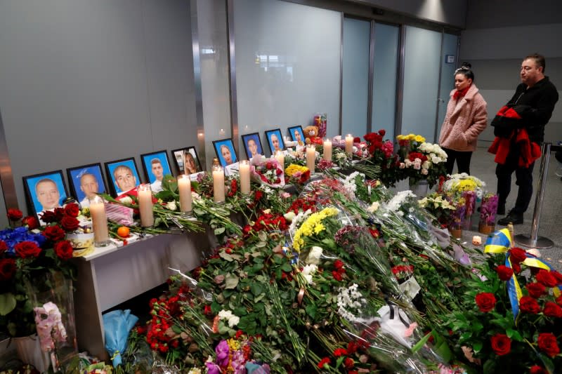 People mourn in front of a memorial for the flight crew members of the Ukraine International Airlines Boeing 737-800 plane that crashed in Iran, at the Boryspil International airport