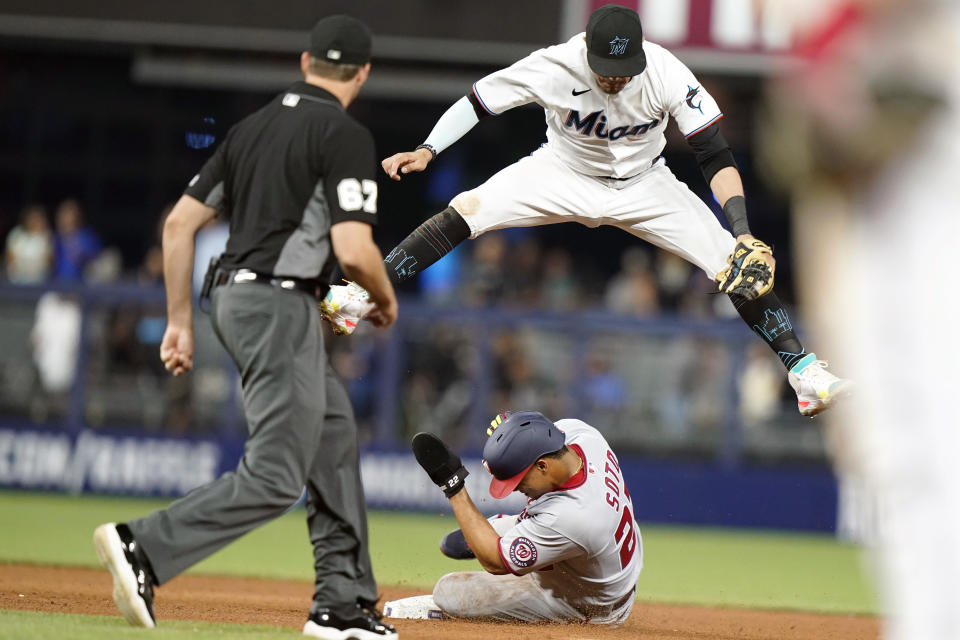 Washington Nationals' Juan Soto (22) beats the throw to Miami Marlins shortstop Miguel Rojas to steal second during the fifth inning of a baseball game, Wednesday, May 18, 2022, in Miami. (AP Photo/Lynne Sladky)