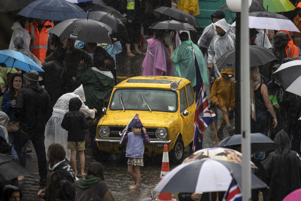 Protesters stand in wet conditions as they voice their opposition to coronavirus vaccine mandates at Parliament in Wellington, New Zealand, Saturday, Feb. 12, 2022. The protest began when a convoy of trucks and cars drove to Parliament from around the nation, inspired by protests in Canada. (George Heard/NZME via AP)