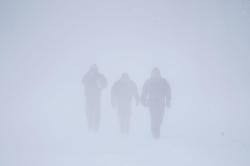 Three men walk down Richmond Avenue in whiteout conditions during a sustained blizzard in Buffalo, N.Y. on Saturday, Dec. 24, 2022. (Derek Gee/The Buffalo News via AP)