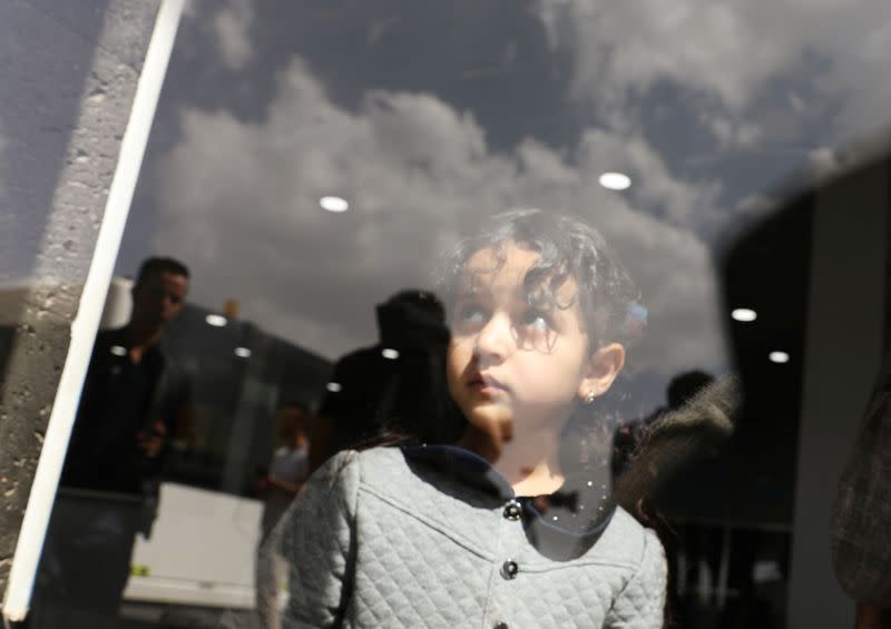 Girl looks from behind a door glass before her boarding on a United Nations plane which will carry her and other patients to Amman, Jordan in the first flight of a medical air bridge from Sanaa airport in Sanaa, Yemen