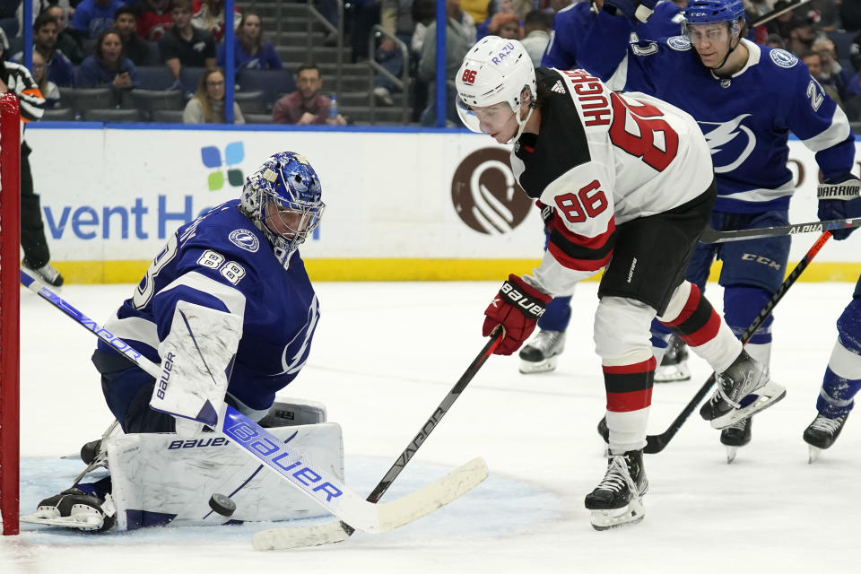 Tampa Bay Lightning goaltender Andrei Vasilevskiy (88) makes a pad save on a shot by New Jersey Devils center Jack Hughes (86) during the third period of an NHL hockey game Thursday, Jan. 27, 2022, in Tampa, Fla. (AP Photo/Chris O'Meara)