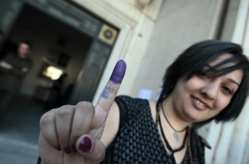 A Syrian woman shows her ink-stained finger after casting her vote at a polling station in Damascus. Syrians voted on Monday in the country's first "multiparty" parliamentary election in five decades, held against a backdrop of violence and dismissed as a sham by the opposition