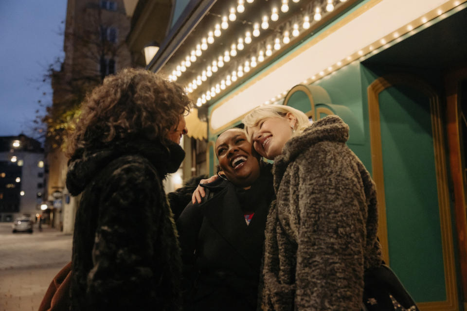 female friends hugging on the sidewalk