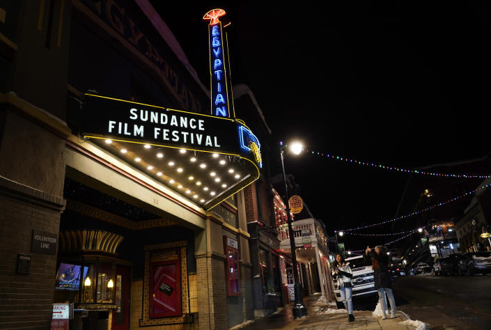 Pedestrians take photos of the marquee of the Egyptian Theatre before the 2023 Sundance Film Festival, Wednesday, Jan. 18, 2023, in Park City, Utah. The annual independent film festival runs from Jan. 19-29. (AP Photo/Chris Pizzello)