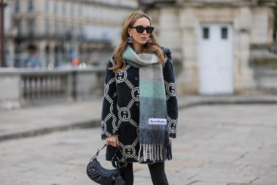 Fashion blogger Alexandra Lapp wears an Acne Studios scarf in green and grey during Paris Fashion Week