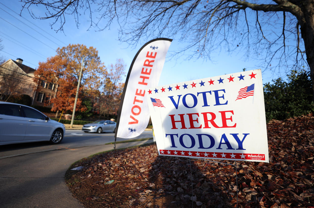 Signs saying Vote Here in front of a polling station.