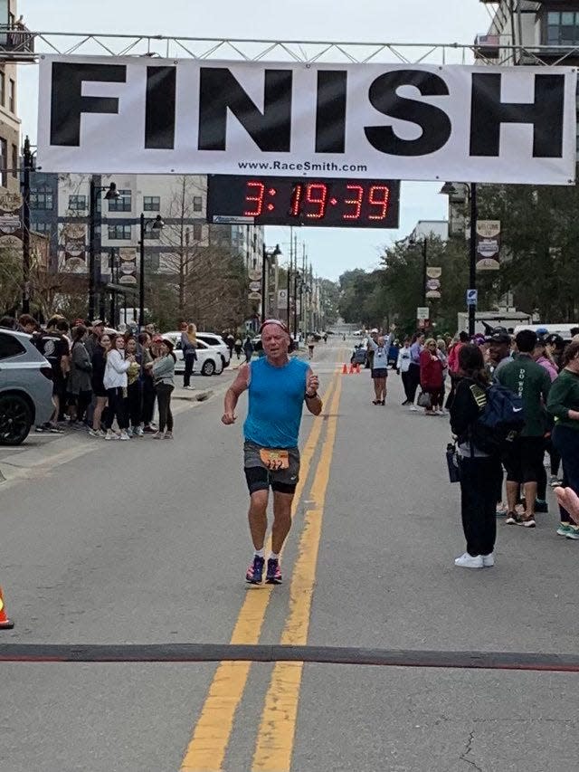 Tallahassee's Jack McDermott crosses the finish line during Sunday's Tallahassee Marathon.