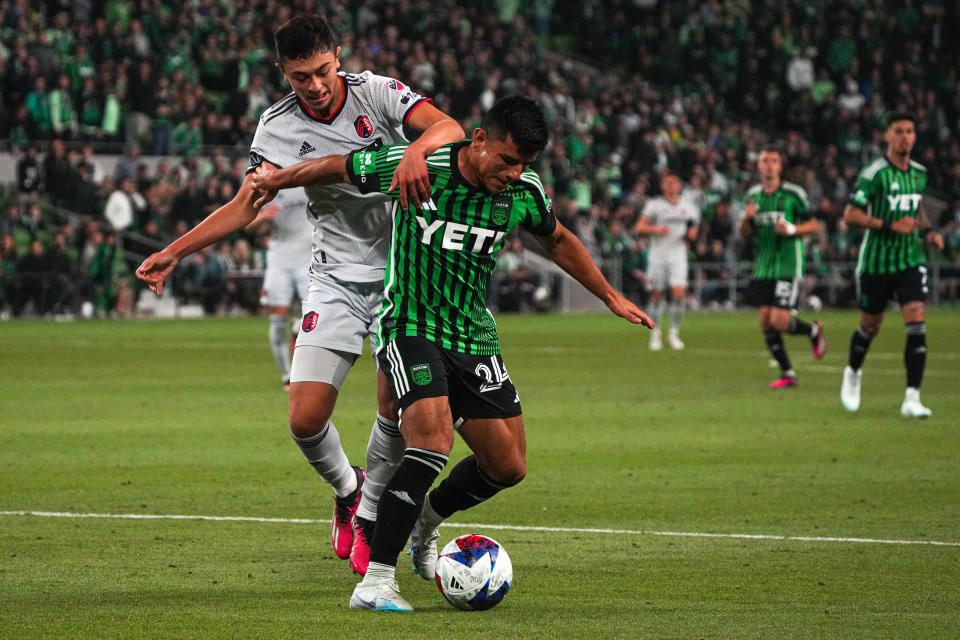 Austin FC defender Nick Lima is hit from behind by a St. Louis City SC defender during Saturday night's season opener at Q2 Stadium.