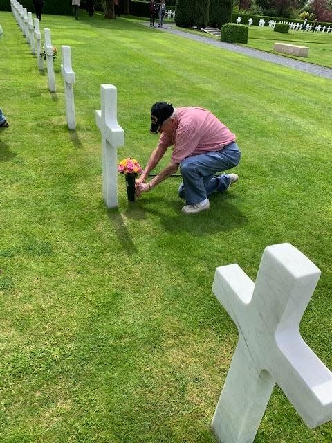 Flat Rock resident and World War II veteran George Sarros places flowers on the grave of a WWI soldier in Flanders Field, Belgium.