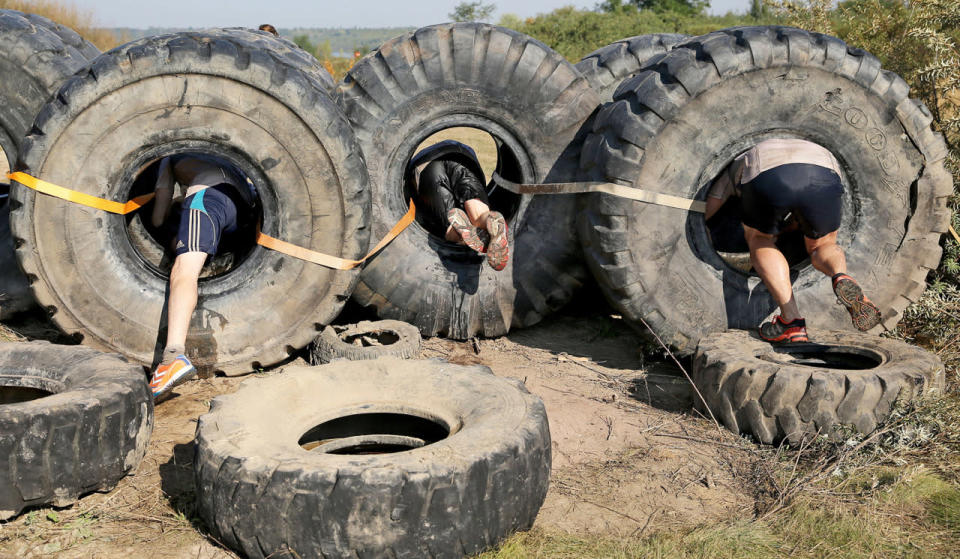 <p>Hobby athletes in action during the ‘Cross De Luxe’ run at Markkleeberger See near Leipzig, Germany, Sept. 25, 2016. More than 3,000 athletes participated during two days in the 8 or 16 kilometer run through water pools, pipes and mud walls. (Photo: JAN WOITAS/EPA)</p>