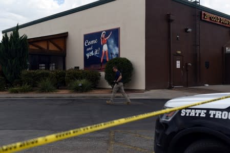 An official investigates the scene at a Twin Peaks restaurant following a shooting in Odessa